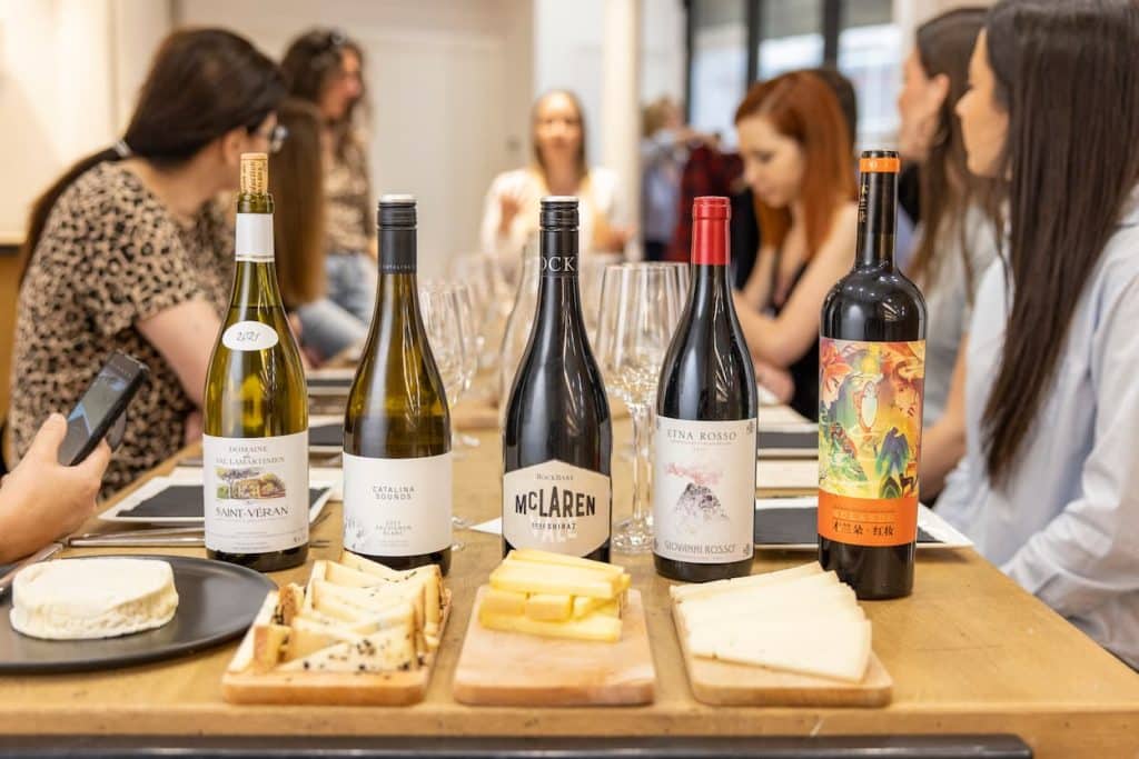 Dégustation de vin privée à Paris avec Jasmina : 5 bouteills en rangée avec 3 plateaux de fromages