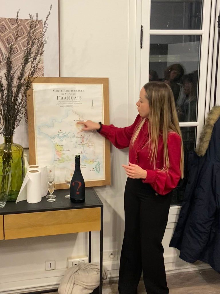 Jasmina briefe les équipes une carte de France à la main pour un Wine Battle